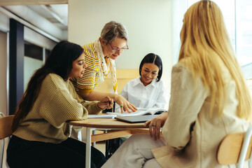 Teacher guiding students in an engaging education session with books and discussions in a bright classroom