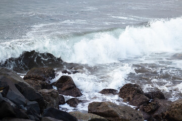 Morning waves crashing against rocks on the shore