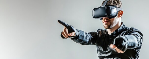 Man using VR headset, pointing, studio shot, grey background, gaming