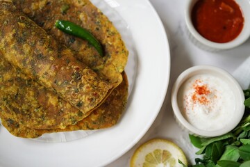 Methi Thepla - Traditional gujarati vegetarian breakfast with fenugreeek leaves and wheat flour served with pickle and yogurt