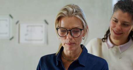 Obraz premium The designer shows the design of the room on a tablet to happy customers