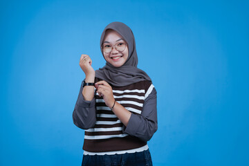 Woman Adjusting Her Wristwatch on a Blue Background