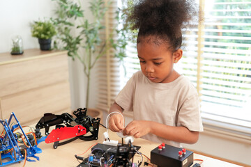 Curious young girl deeply focused on assembling a robotic arm, engaging in a hands-on STEM activity that encourages creativity, problem-solving, and early engineering skills at home