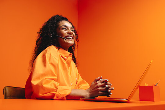 Smiling virtual assistant in vibrant, colorful office setting emphasizing creativity and modernity