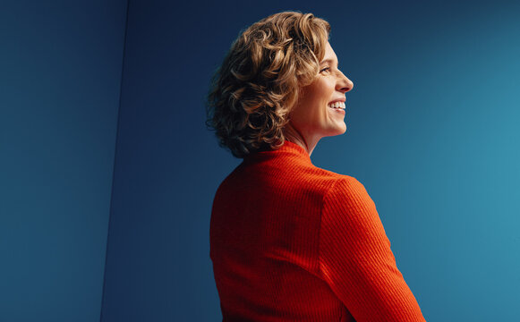 Mature professional woman in vibrant, monochromatic studio set with bold colorblocking elements