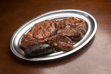 Delicious grilled meat platter featuring steak, sausage, and black pudding, perfect for a hearty meal