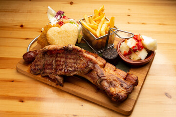 Delicious venezuelan grilled meat, chorizo, arepa, french fries, yuca, and morcilla served on a...