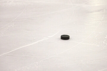 Ice Hockey Puck laying on ice hockey arena rink ice.
