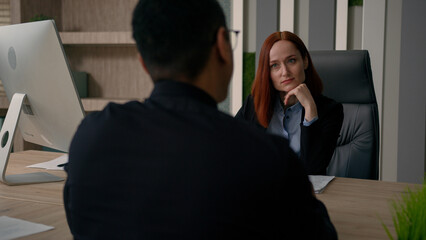Fototapeta premium Two colleagues partners multiracial African american businessman Caucasian businesswoman talk in office business negotiation discuss deal startup financial investment bank insurance offer negotiate