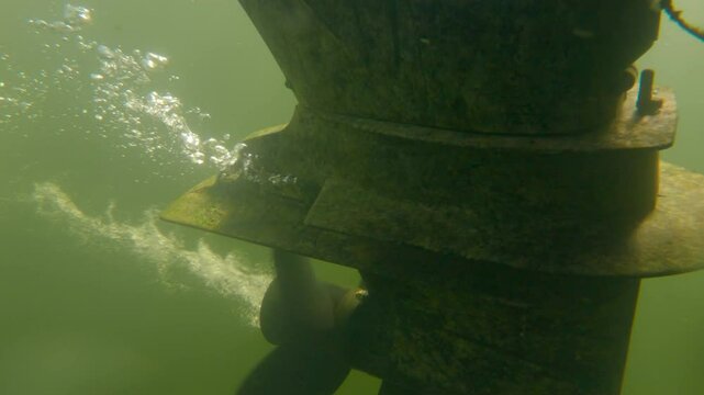 Underwater Shot of a Boat Motor Propeller Spinning