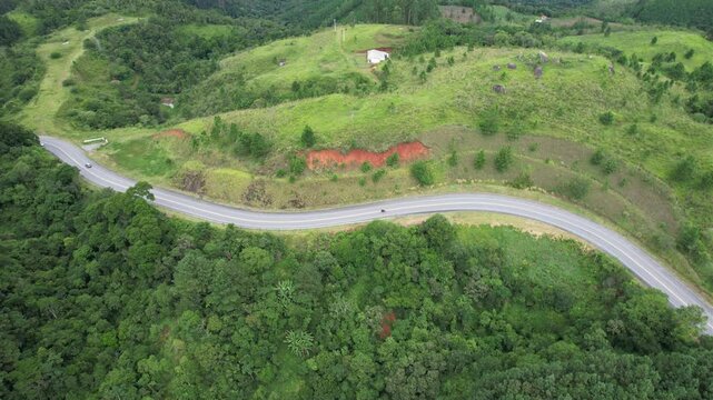 Ve&iacute;culos trafegando em uma estrada no interior de S&atilde;o Paulo, Brasil, vistos do alto com uso de drone.