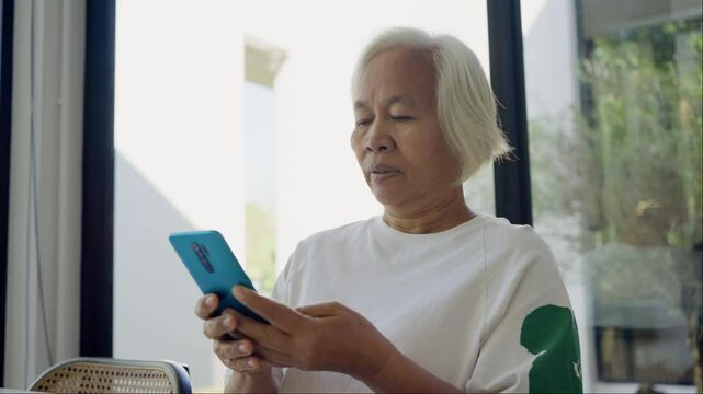 Phone scam call target talk old asian female cyber crime fraud alert on older people. Mature adult retired woman asia parent avoid look at text threats mobile buy pay online banking app social media.