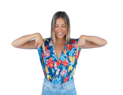 Young smiling woman wearing colorful shirt pointing fingers down isolated over transparent background. PNG transparent.