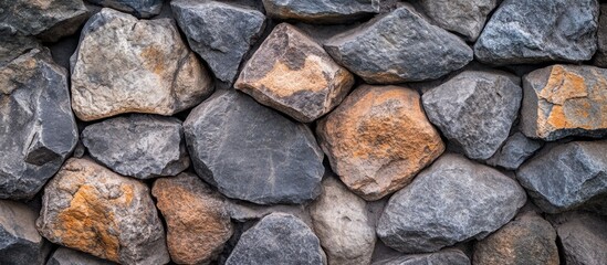 Fototapeta premium Stone wall texture with irregular gray and brown rocks tightly fitted together