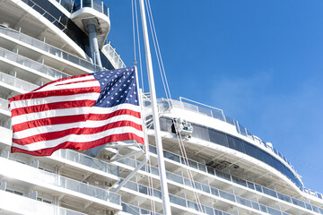 American Flag at half mast in front of cruise ship