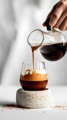 Barista pouring coffee from modern glass carafe into elegant cup minimalist kitchen beverage indoor close-up artistry