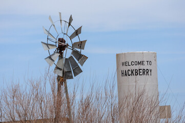 Rustic windmill and Hackberry sign on Route 66 capture road trip nostalgia