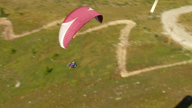 D&eacute;collage et vol d'un parapente violet et blanc au dessus en montagne