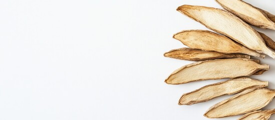 Dried herbal root slices arranged on a white background with copy space for text placement