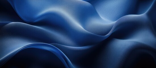 Fototapeta premium Soft flowing blue satin fabric texture with gentle creases and waves suitable for backgrounds and textile-related designs Copy Space