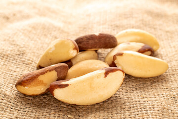 Several Brazil nuts on jute cloth, close-up.