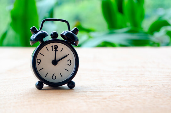 Table alarm clock pointing at 2pm or 2am with customizable space for text. Time management concept and copy space