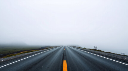 Naklejka premium Empty asphalt road disappearing into the fog on a cloudy day