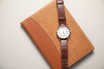Brown elegant wristwatch with a notepad.