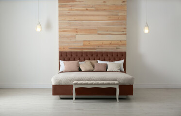 Bed in mocha mousse shade indoors. Cozy bedroom interior. Trendy color of 2025 year