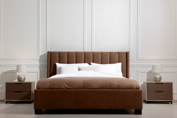 Large bed in mocha mousse shade and nightstands indoors. Trendy color of 2025 year in interior design