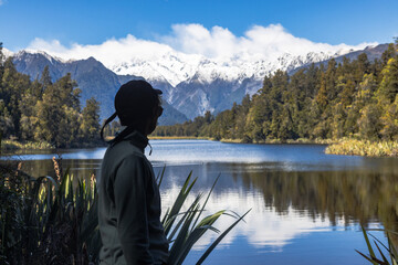 Tourist admiring lake matheson and mount cook in new zealand