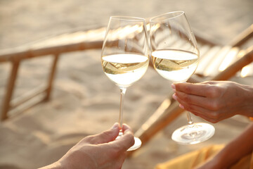 Romantic couple drinking wine together on beach, closeup