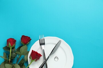 Beautiful setting for romantic dinner, engagement ring and roses on light blue background, flat lay. Space for text
