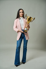 Confident woman holding a trophy