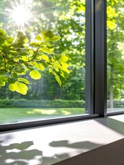 Obraz premium Sunlit Greenery Through Modern Window - Sunlight streams through a modern window, illuminating vibrant green leaves and casting shadows on a light-colored sill. Nature, light, architecture, serenity