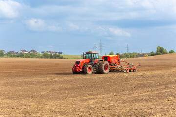 Obraz premium A tractor with a pneumatic seeder attached sows