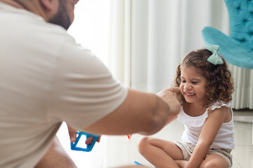 Obraz premium menina brincando com o pai na sala