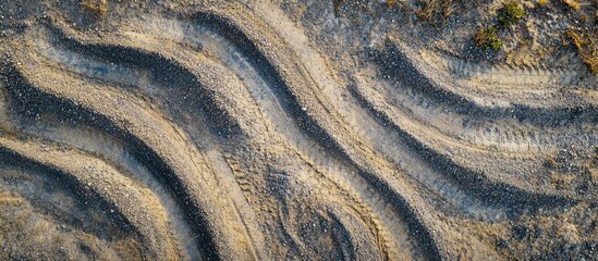 Wavy tire tracks on sandy ground surface with natural textures and patterns Copy Space
