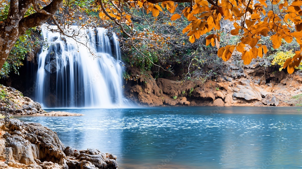 Wall mural Serene waterfall cascading into a tranquil pool surrounded by vibrant autumn foliage