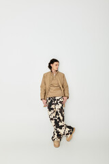 Fototapeta premium Handsome young man stands gracefully, showcasing his fashionable attire with poise and charm.