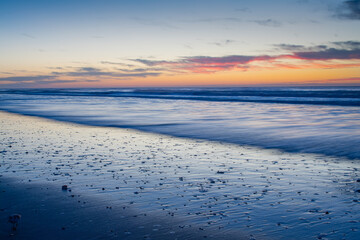 Long Exposure of Waves Rolling in on the Beach at Sunrise