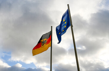 Flags of EU and Germany waving on flagpole in Berlin.