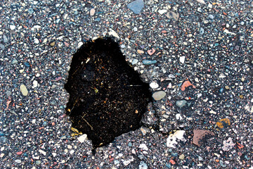close-up of a pothole in the road transportation abstract background metaphor for obstacles hazard...
