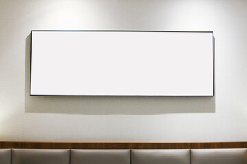 Obraz premium Empty picture frame on a hotel wall with blank white space. Minimalist interior design with copy space for artwork. Modern hotel room wall decor with an empty painting frame ready for display.