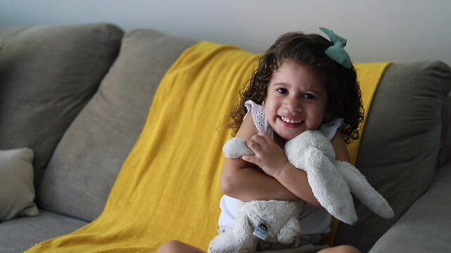 menina abra&ccedil;ando um urso de pel&uacute;cia 