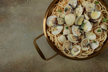 spaghetti with vongole clams, in cream sauce, carbonara, in a brass pan, homemade, top view, no people,