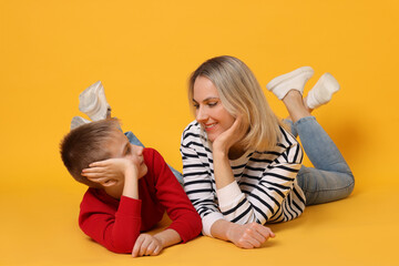 Happy mother and son on orange background