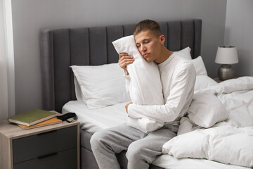 Young man suffering from sleepwalking on bed at home