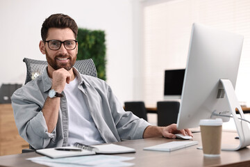 Obraz premium Man working on computer at table in office