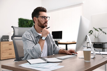 Fototapeta premium Man working on computer at table in office